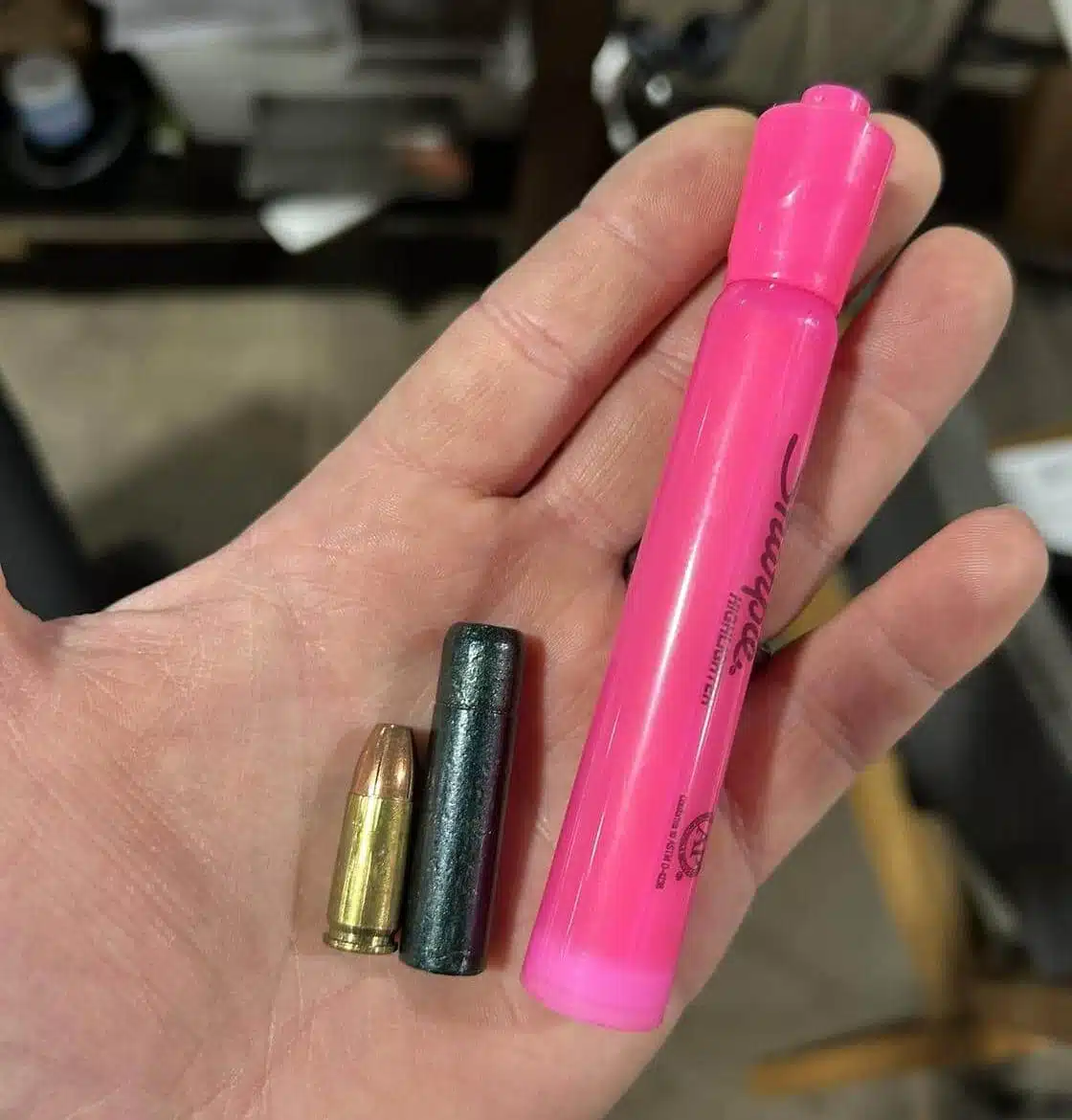 Size comparison of 777gr Lucky Ram bullet with 9mm cartridge and pink highlighter—showcasing extreme length and mass of subsonic 45-70 projectile