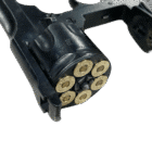 A blued Webley shim, loaded with 6 rounds, inserted into a revolver.