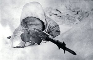 Finnish sniper Simo Häyhä, known as the “White Death” tracks a target over the open sights of his Mosin-Nagant rifle. Image Source: Warfare History Network[