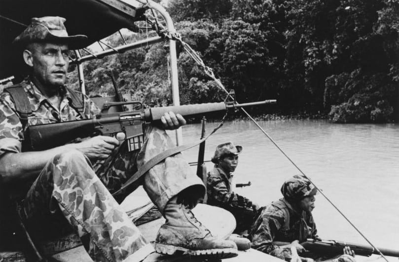 An early M16 rifle without forward-assist. Note: "duckbill" flash suppressor and triangular handguard.